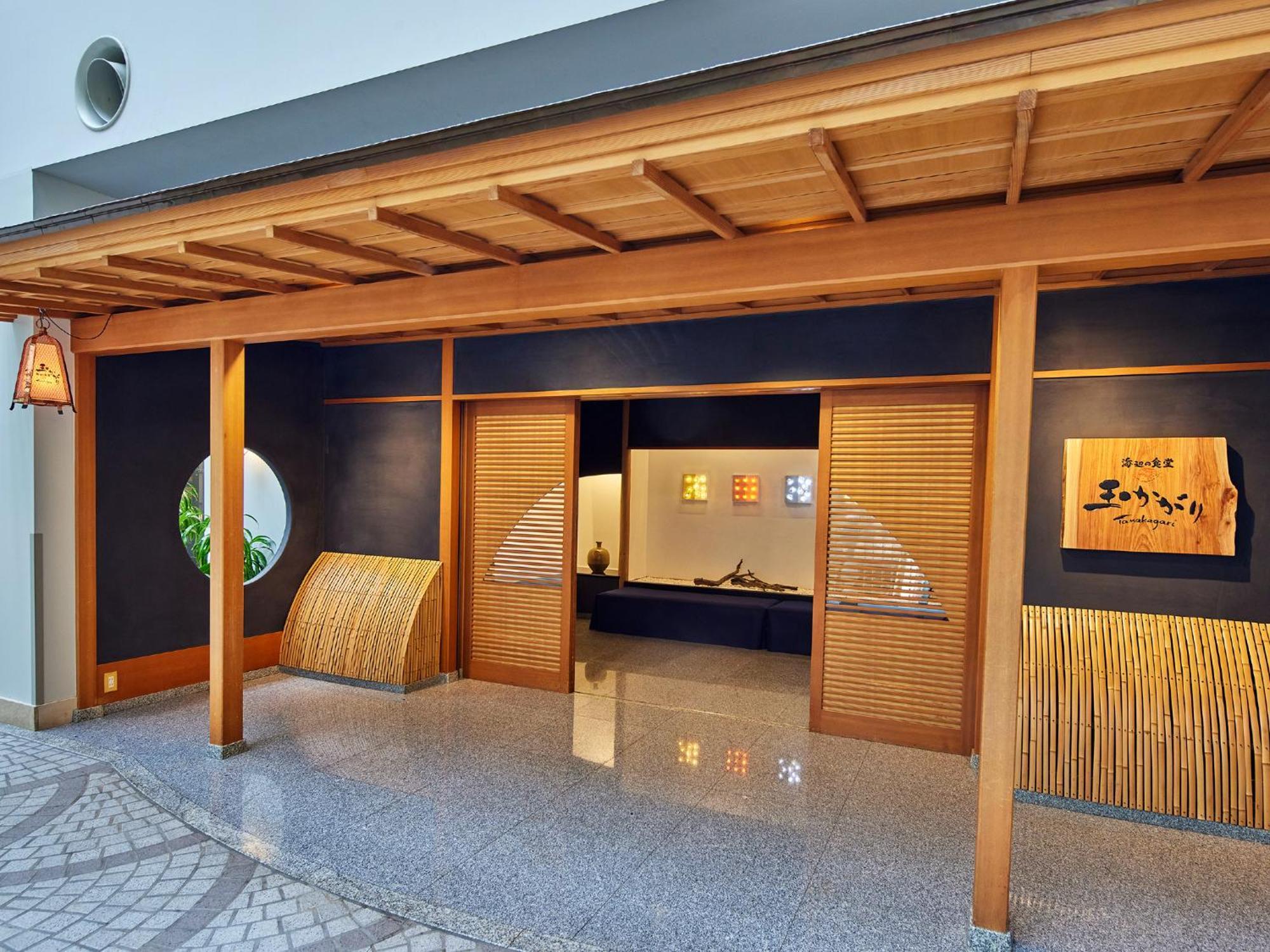 Hotel Grand Nikko Tokyo Bay Maihama Urayasu Exteriér fotografie The photo shows the entrance of a building, designed in a traditional Japanese style. It features a wooden structure with a large overhanging roof and sliding doors. The entrance is flanked by rounded windows, and there's a decorative sign with Japan