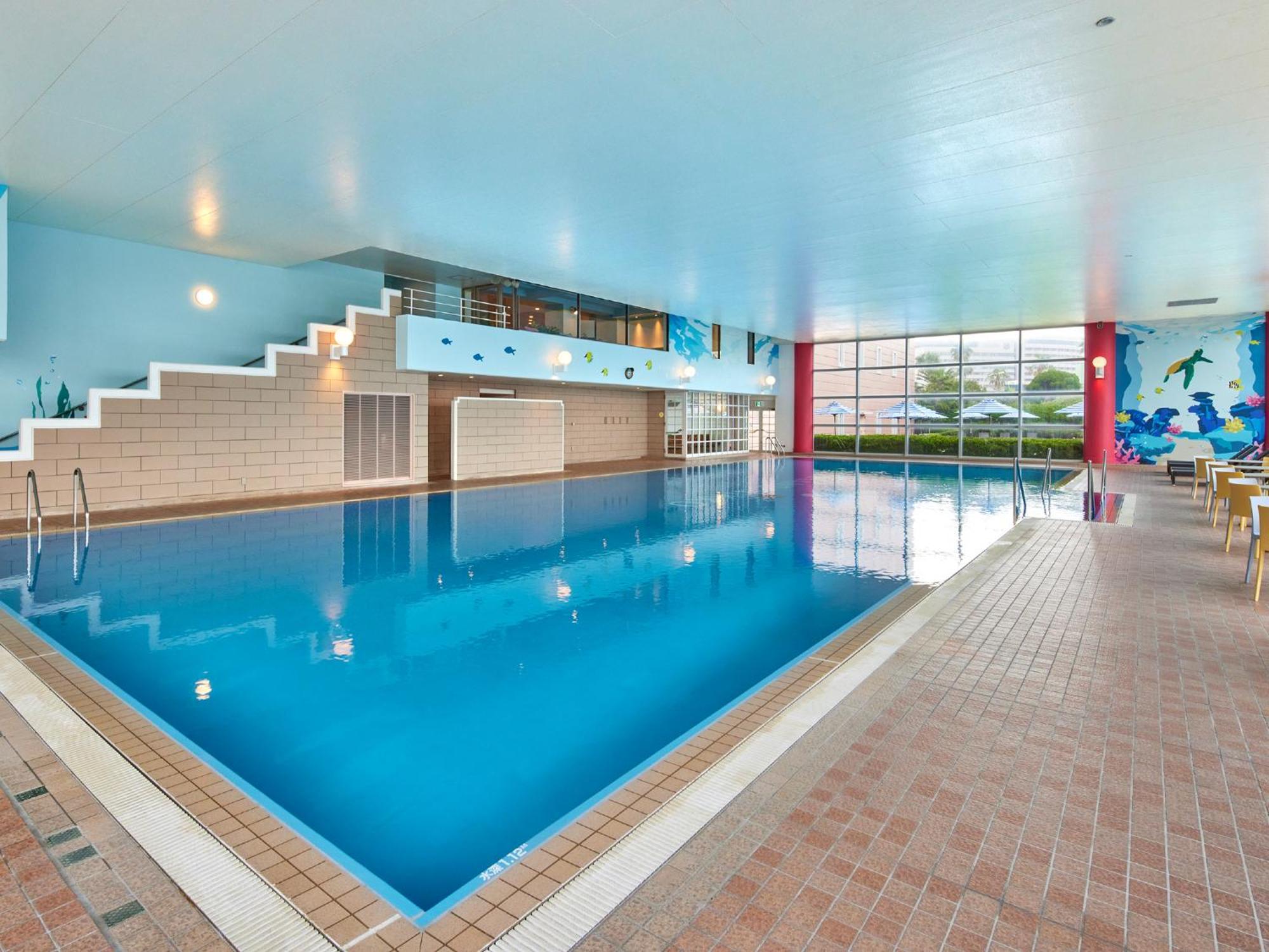 Hotel Grand Nikko Tokyo Bay Maihama Urayasu Exteriér fotografie The photo shows an indoor swimming pool area with a spacious design. The pool has a clear blue water surface and is surrounded by a tiled deck. On one side of the pool, there are steps leading into the water, and there are large windows letting in na