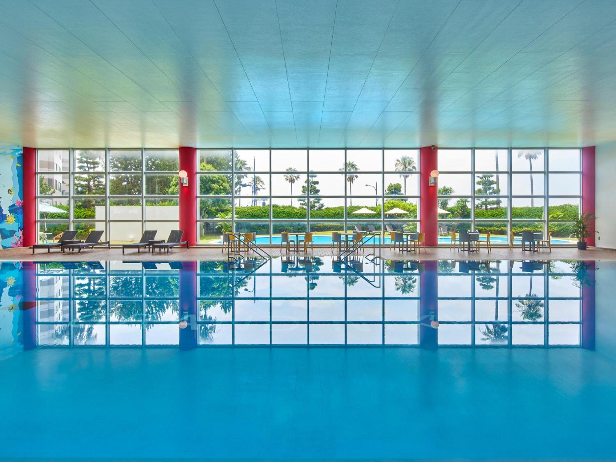 Hotel Grand Nikko Tokyo Bay Maihama Urayasu Exteriér fotografie The photo shows an indoor swimming pool with bright blue water. The pool area is spacious, characterized by large windows that allow natural light to flood in, creating a vibrant atmosphere. The walls are painted in a soft color, with accents of red.